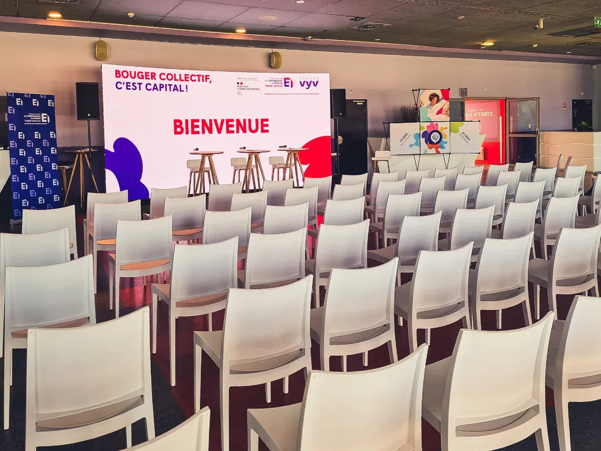 Salle de séminaire aménagée par OC Évènement, chaises et scène