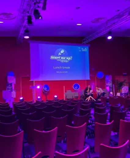 Salle de congrès éclairée en violet avec écran